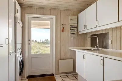 a kitchen with white cabinets and a door with a window at BL1386-Saltum-Kordalslien-7 in Saltum