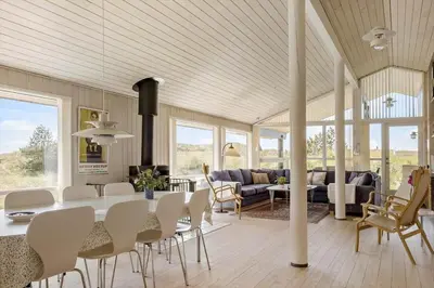 a dining room and living room with a table and chairs at BL1386-Saltum-Kordalslien-7 in Saltum