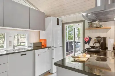a kitchen with white cabinets and a counter top at BL226-Blokhus-Paa-Bakken-13 in Blokhus