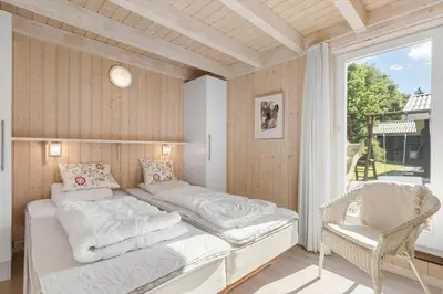 a bedroom with a large bed and a window at BL226-Blokhus-Paa-Bakken-13 in Blokhus