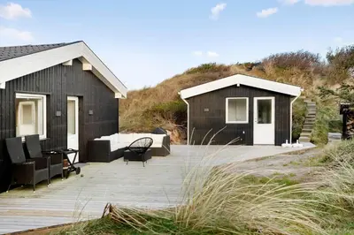 a house with a wooden deck and a house at BL332-Saltum-Svendborgvej-18 in Saltum
