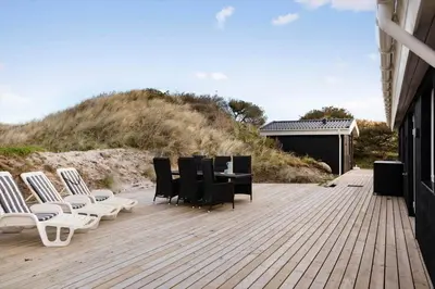 a wooden deck with chairs and a table on a beach at BL332-Saltum-Svendborgvej-18 in Saltum