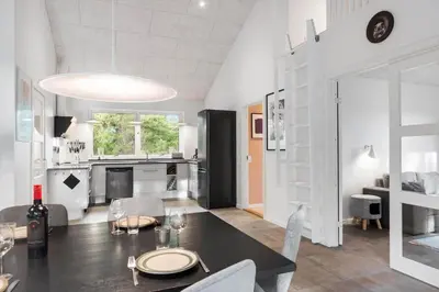 a dining room and kitchen with a table and chairs at BL1266-Pandrup-Rodhusparken-58 in Pandrup