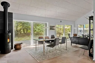 a dining room with a table and chairs and a fireplace at BL1266-Pandrup-Rodhusparken-58 in Pandrup