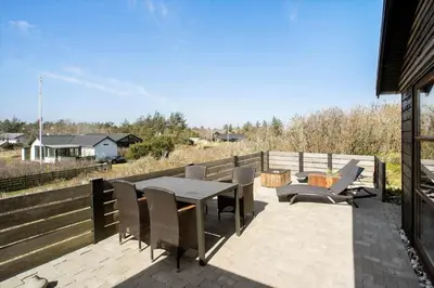 a patio with a table and chairs and a fence at BL789-Blokhus-Pirupshvarrevej-20 in Blokhus