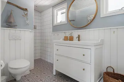 a bathroom with a sink and a toilet and a mirror at BL1640-Blokhus-Solbakkevej-2 in Blokhus