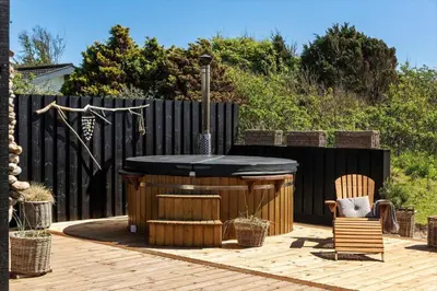 a backyard with a hot tub and a wooden deck at BL1640-Blokhus-Solbakkevej-2 in Blokhus