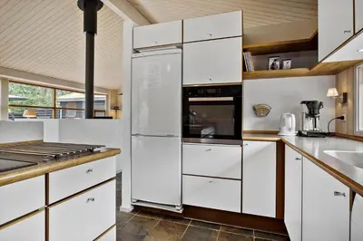 a kitchen with white cabinets and a stove top oven at BL100-Blokhus-Morten-Nielsensvej-19 in Blokhus