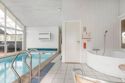 a large bathroom with a tub and a swimming pool at BL119-Blokhus-Egebaeksvej-20 in Blokhus