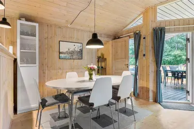 a dining room with a white table and chairs at BL762-Blokhus-Berberisvej-49 in Blokhus