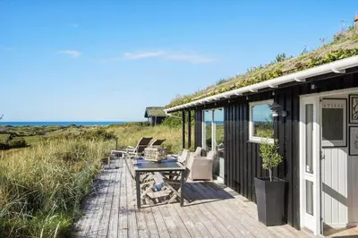 a wooden deck with a table and chairs on the beach at BL867-Saltum-Karen-Mariesvej-48 in Saltum