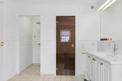 a white bathroom with a shower and a sink at BL518-Blokhus-Ferren-Syd-86 in Blokhus