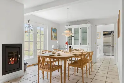 a dining room with a table and a fireplace at BL518-Blokhus-Ferren-Syd-86 in Blokhus