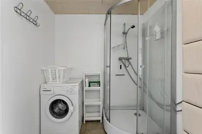 a bathroom with a washing machine and a shower at BL380-Pandrup-Rodhus-Skolevej-1 in Pandrup
