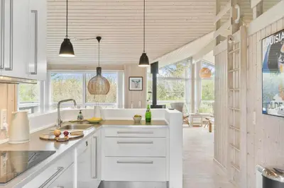 a kitchen with white cabinets and windows at BL1227-Saltum-Porsevej-31 in Saltum