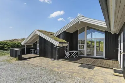a black house with a roof with a patio at BL201-Saltum-Kalundborgvej-21 in Saltum