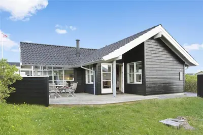 a small house with a porch and a patio at BL637-Blokhus-Klitvejen-35 in Blokhus