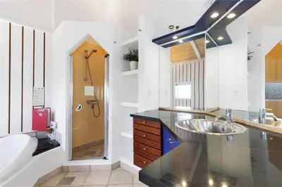a bathroom with a sink and a mirror and a tub at BL637-Blokhus-Klitvejen-35 in Blokhus