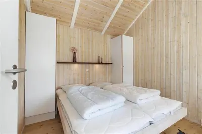 a bedroom with a large bed with white pillows at BL637-Blokhus-Klitvejen-35 in Blokhus