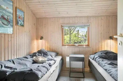 a small room with a bed and a window at BL1313-Blokhus-Bag-Hojen-3 in Blokhus