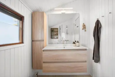 a bathroom with a sink and a mirror at BL1313-Blokhus-Bag-Hojen-3 in Blokhus