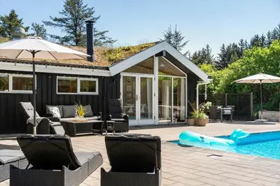a backyard with a pool and a house at BL1313-Blokhus-Bag-Hojen-3 in Blokhus