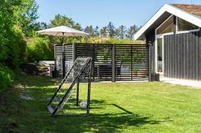 a soccer ball on a swing set in a yard at BL1313-Blokhus-Bag-Hojen-3 in Blokhus