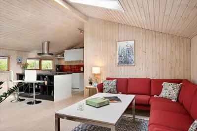 a living room with a red couch and a table at BL1313-Blokhus-Bag-Hojen-3 in Blokhus