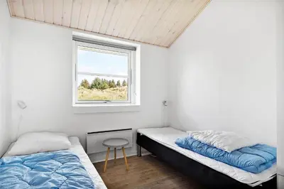 a bedroom with two beds and a window at BL417-Blokhus-Saetergaardsstien-6-A in Blokhus