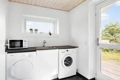 a white laundry room with a washer and dryer at BL417-Blokhus-Saetergaardsstien-6-A in Blokhus