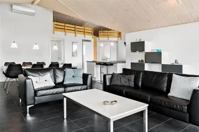 a living room with black leather furniture and a table at BL417-Blokhus-Saetergaardsstien-6-A in Blokhus