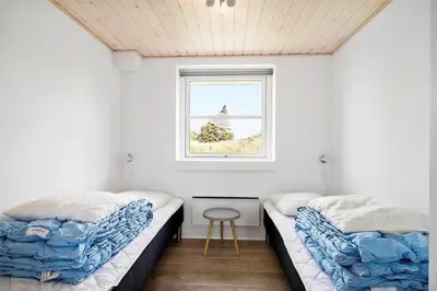 two beds in a room with a window at BL417-Blokhus-Saetergaardsstien-6-A in Blokhus