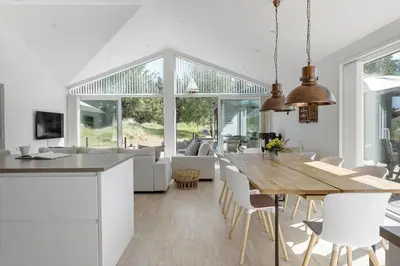 a kitchen and living room with a table and chairs at BL1777-Blokhus-Lyngbakkevej-10 in Blokhus