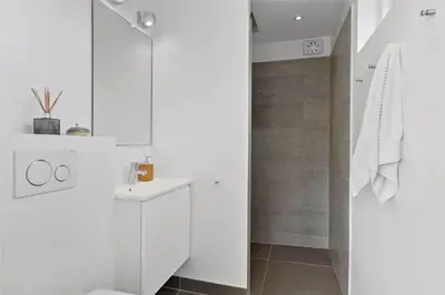 a white bathroom with a shower and a sink at BL1777-Blokhus-Lyngbakkevej-10 in Blokhus
