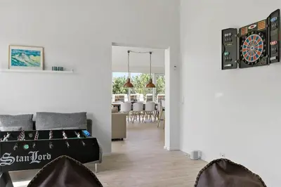 a living room with a couch and a dartboard on the wall at BL1777-Blokhus-Lyngbakkevej-10 in Blokhus