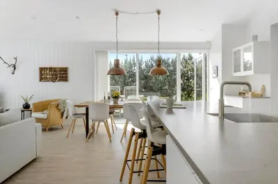 a kitchen and dining room with a table and chairs at BL1777-Blokhus-Lyngbakkevej-10 in Blokhus