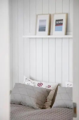 a room with a white wall with a shelf with pictures at BL1777-Blokhus-Lyngbakkevej-10 in Blokhus