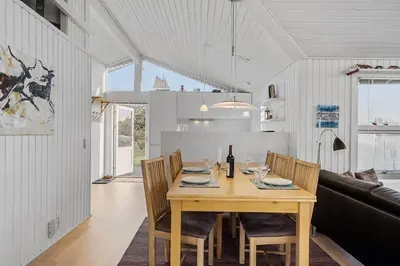 a dining room with a wooden table and chairs at BL1770-Saltum-Klittornvej-5 in Saltum