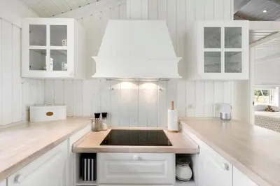 a white kitchen with a sink and a chandelier at BL653-Saltum-Nordvestvej-27 in Saltum