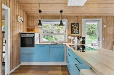 a kitchen with blue cabinets and a window at BL1627-Blokhus-Lyngvej-17 in Blokhus