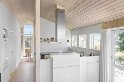 a kitchen with white cabinets and a wooden ceiling at BL809-Pandrup-Lommelaerken-20 in Pandrup