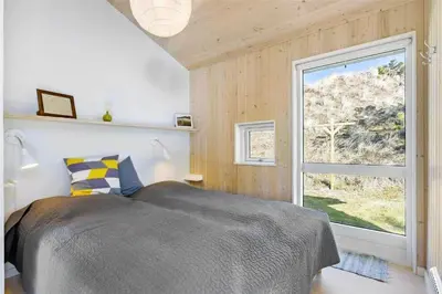 a bedroom with a bed and a large window at BL809-Pandrup-Lommelaerken-20 in Pandrup
