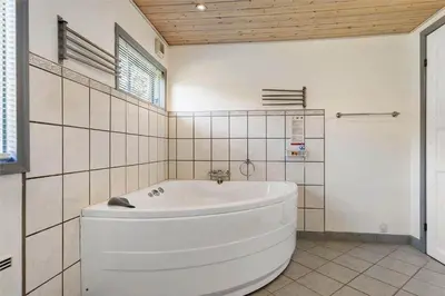 a white bath tub in a white tiled bathroom at BL613-Blokhus-Septimusvej-9 in Blokhus