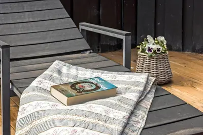 a book sitting on a blanket on a bench at BL1739-Blokhus-Bag-Hojen-47 in Blokhus