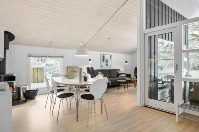 a kitchen and living room with a table and chairs at BL1739-Blokhus-Bag-Hojen-47 in Blokhus