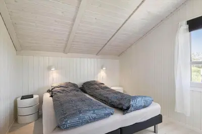 a bedroom with two beds in a white room at BL1477-Blokhus-Park-Alle-5 in Blokhus