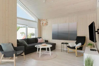 a living room with a couch and chairs and a tv at BL1477-Blokhus-Park-Alle-5 in Blokhus