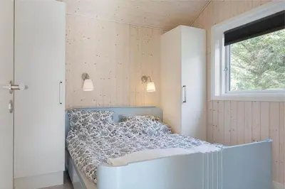a bed in a room with a window at BL1477-Blokhus-Park-Alle-5 in Blokhus