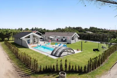 a home with a swimming pool and a house at BL1477-Blokhus-Park-Alle-5 in Blokhus
