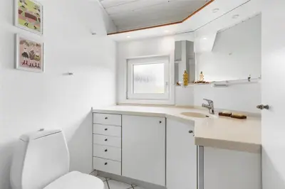 a white bathroom with a toilet and a sink at BL1555-Blokhus-Egebaeksvej-17 in Blokhus